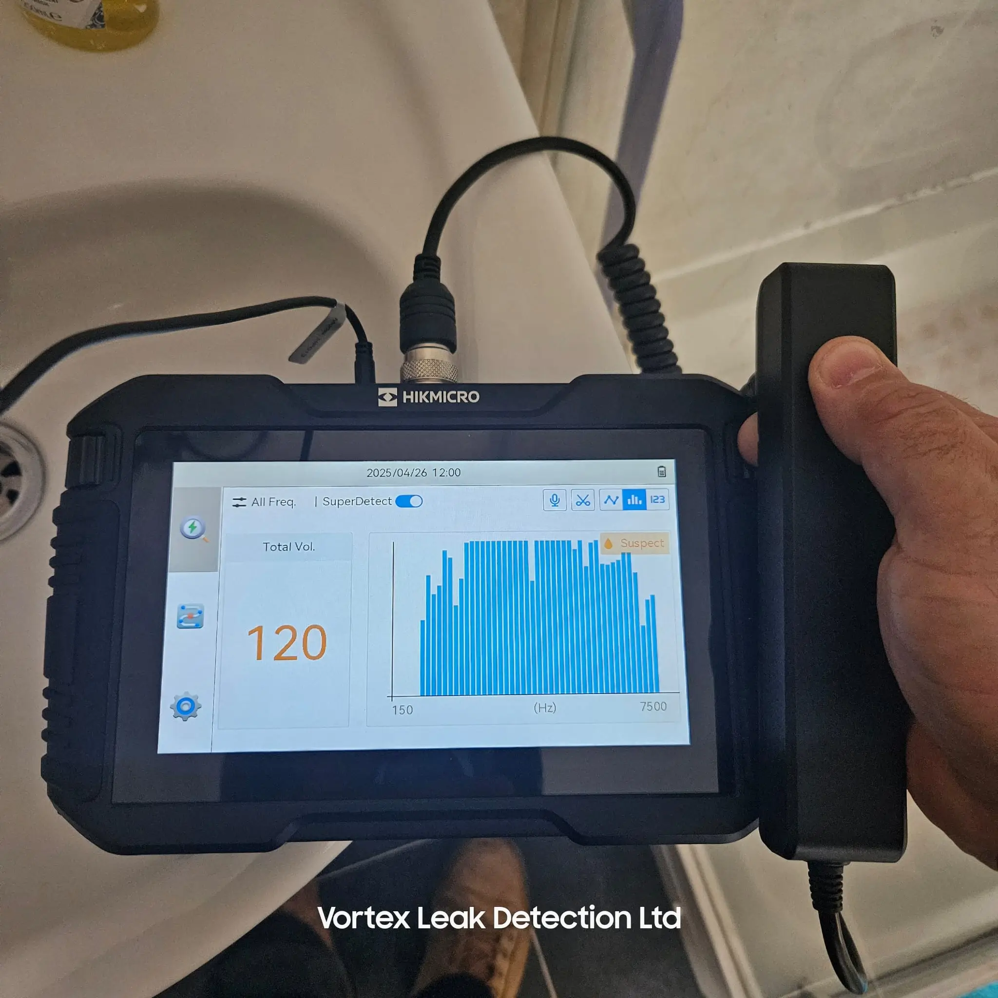 Hikmicro AD21P acoustic device displaying sound frequencies for leak detection near a sink.